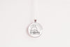 Necklace with a pendant featuring a design of a cat sitting on a stack of books, shown on a white background
