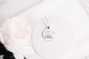 Necklace with a pendant featuring a design of a cat sitting on a stack of books, shown on a white background