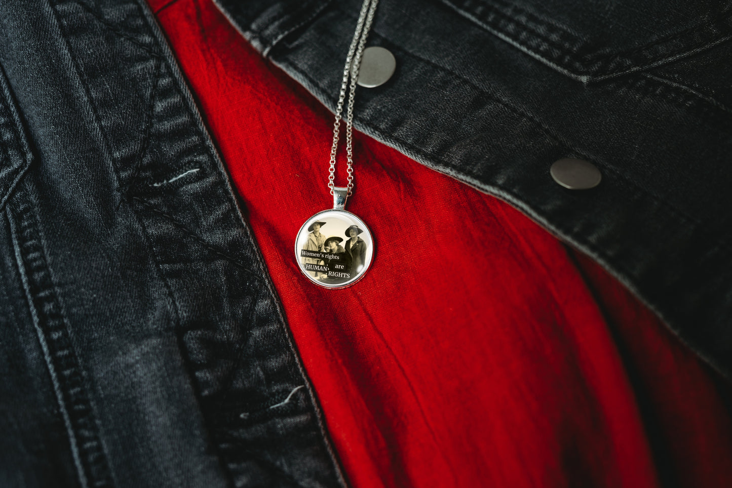 Product photo of a 1-inch glass cabochon pendant necklace featuring “Women’s Rights Are Human Rights” with a group of vintage women in wide-brim hats on a 20-inch chain.