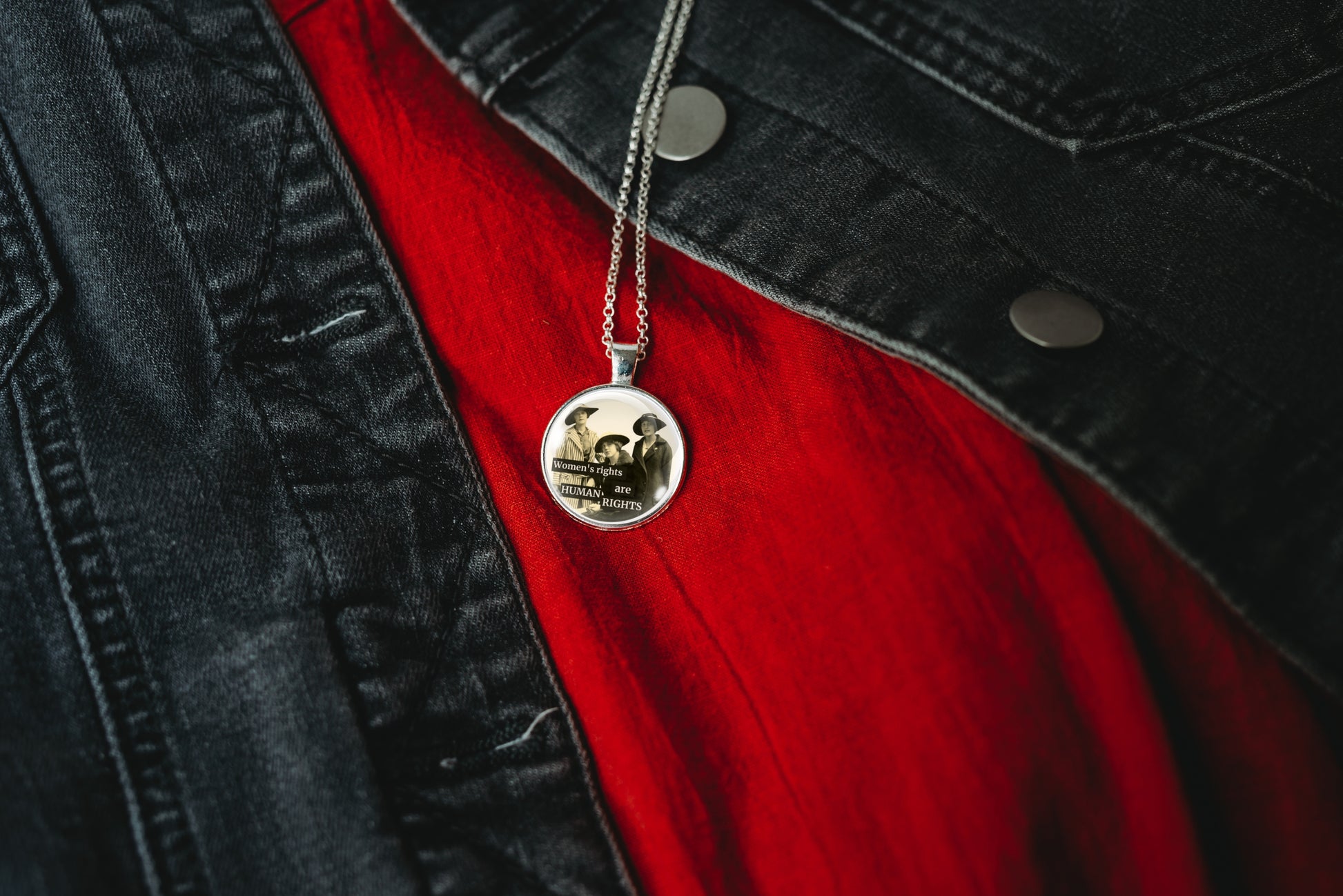 Product photo of a 1-inch glass cabochon pendant necklace featuring “Women’s Rights Are Human Rights” with a group of vintage women in wide-brim hats on a 20-inch chain.