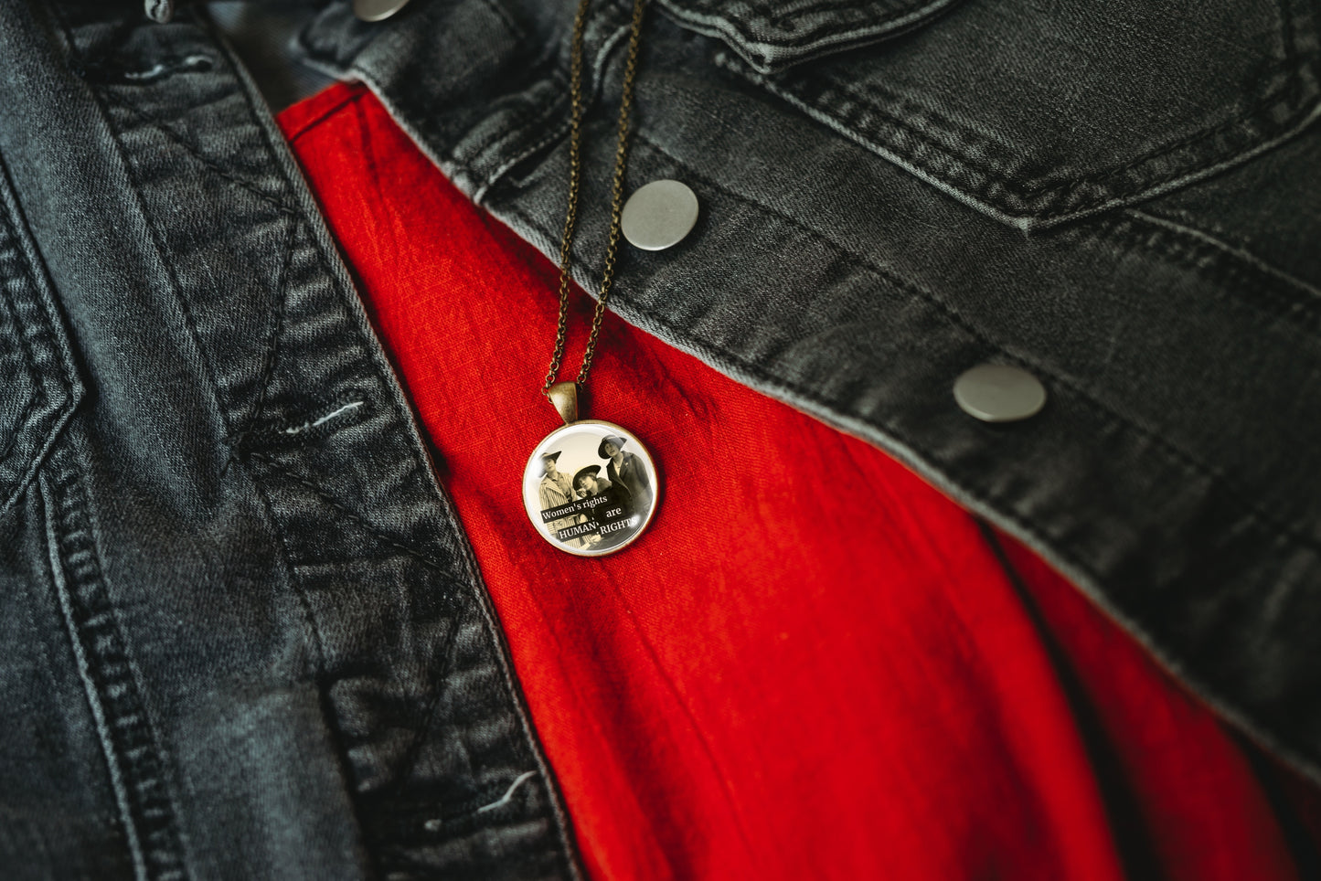Product photo of a 1-inch glass cabochon pendant necklace featuring “Women’s Rights Are Human Rights” with a group of vintage women in wide-brim hats on a 20-inch chain.
