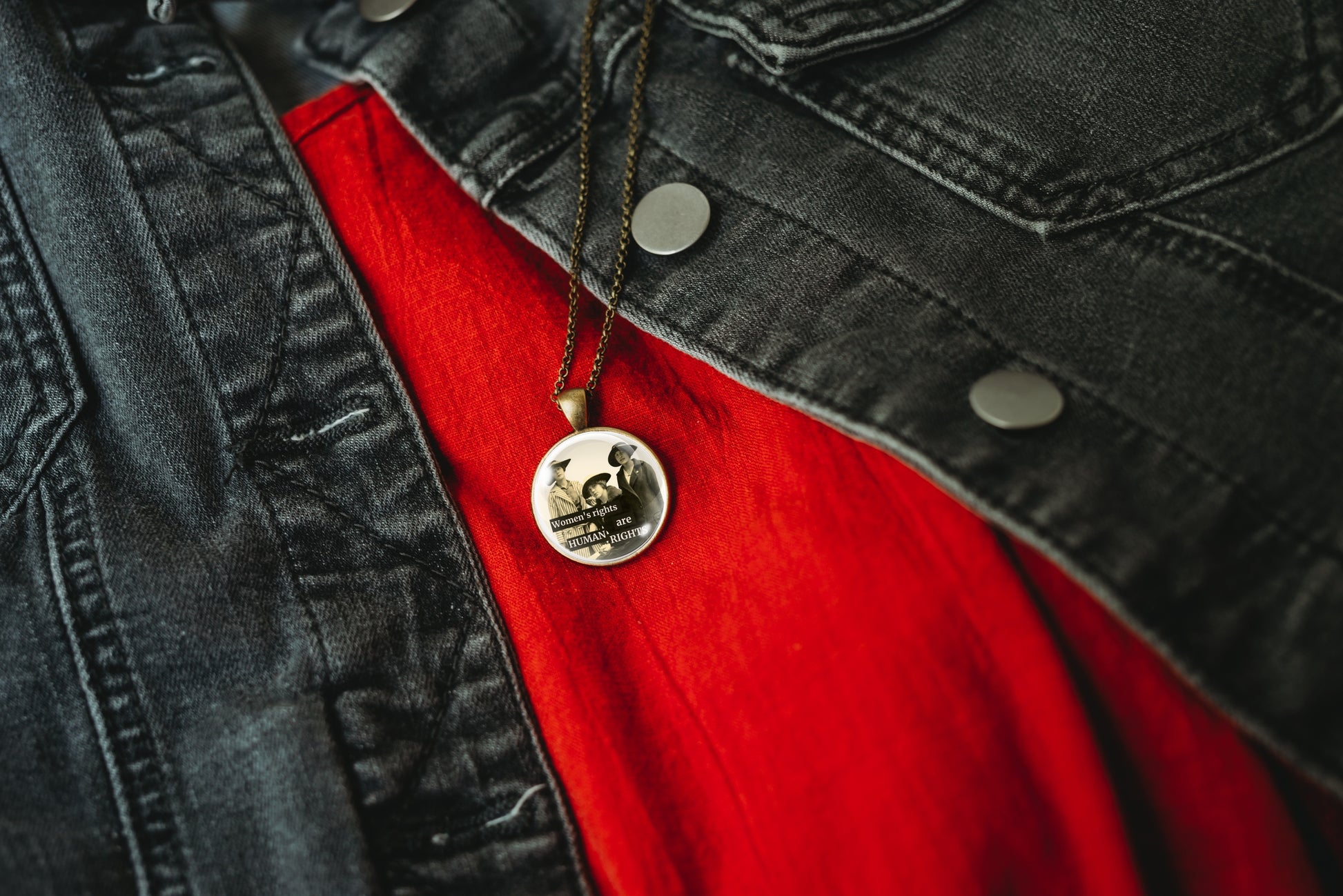 Product photo of a 1-inch glass cabochon pendant necklace featuring “Women’s Rights Are Human Rights” with a group of vintage women in wide-brim hats on a 20-inch chain.