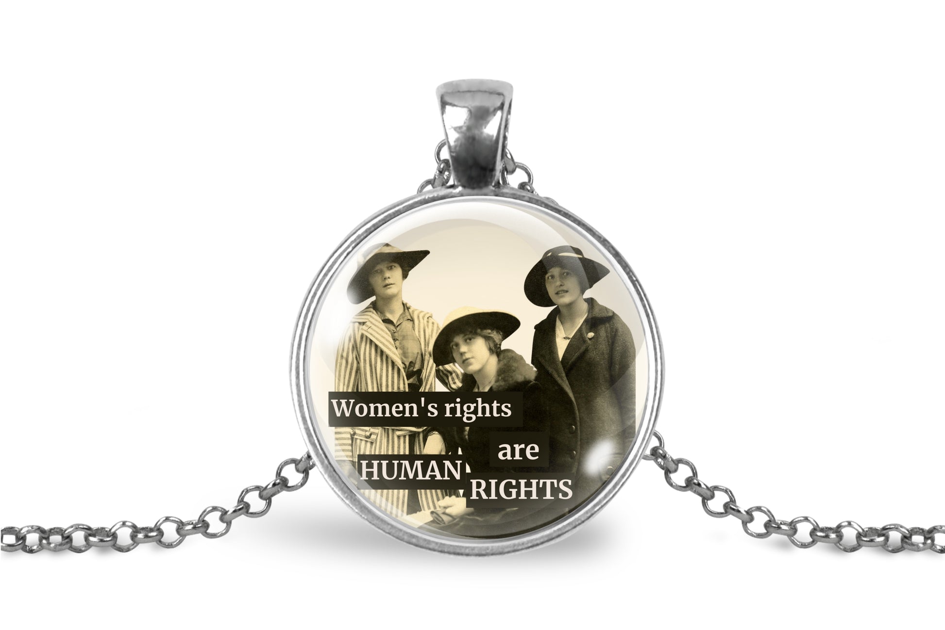 A silver pendant necklace featuring a circular glass dome with a sepia-toned historical photograph of three women and the text 'Women's rights are HUMAN RIGHTS'.