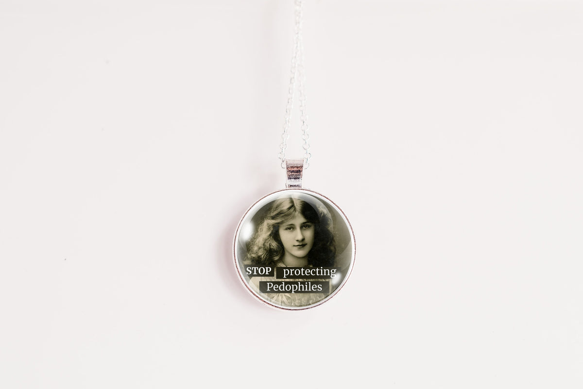 A silver circular pendant necklace hanging against a plain white background. The pendant contains a black-and-white portrait of a woman and the text 'STOP protecting Pedophiles' in white lettering.