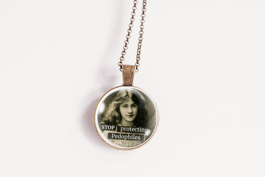 A round pendant necklace on a delicate chain, featuring a printed graphic of a young girl with the text 'STOP protecting Pedophiles' on a plain white background.