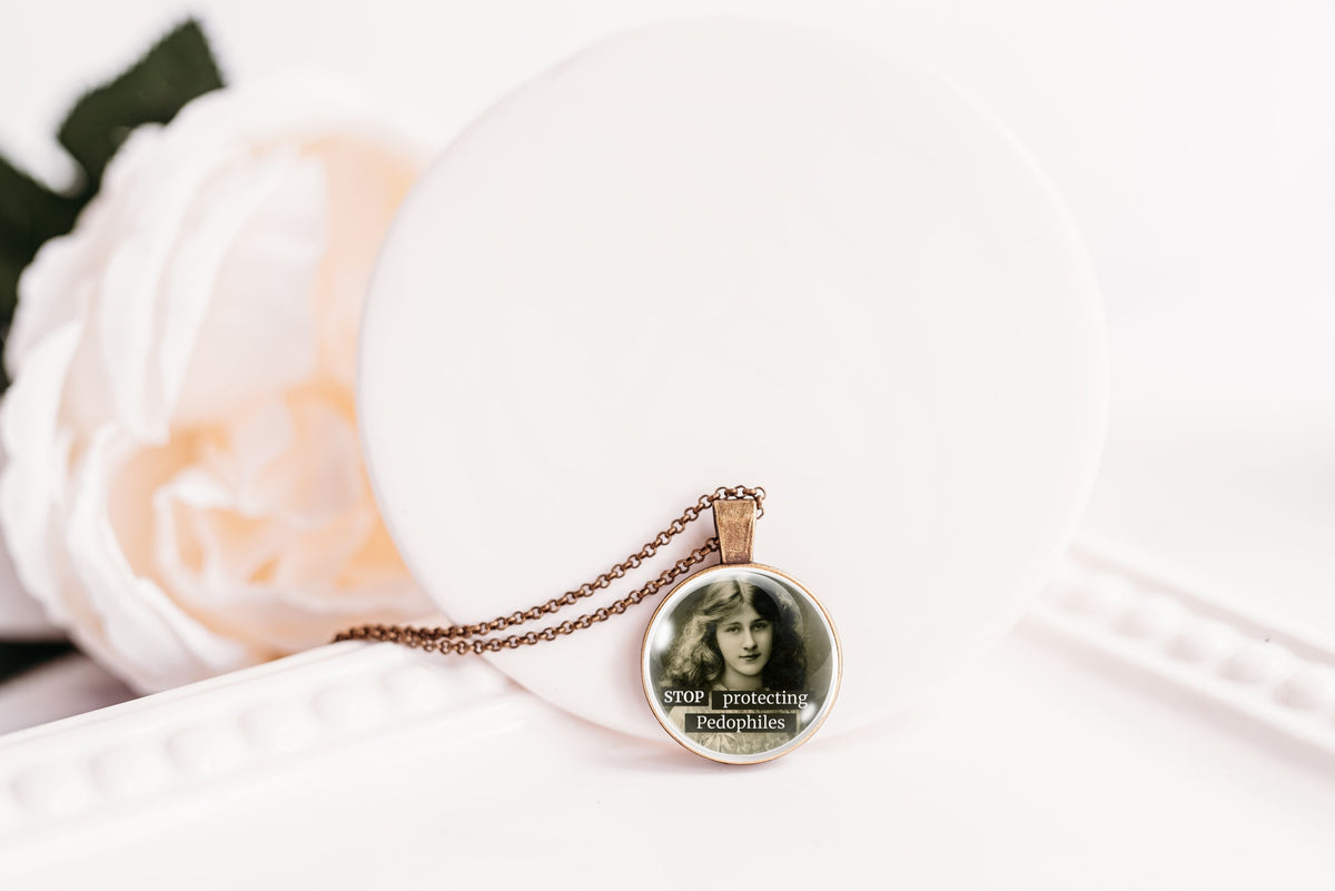 Product photo of a 1-inch glass cabochon pendant necklace featuring “Stop Protecting Pedophiles” with a black-and-white portrait of a long-haired vintage woman on a 20-inch chain.