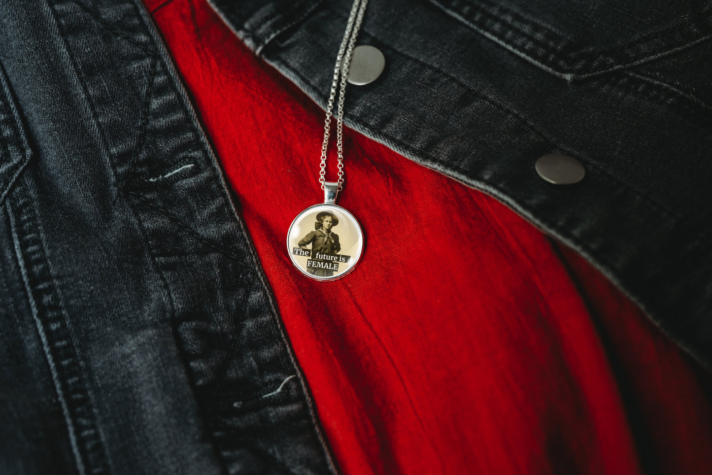 Product photo of a 1-inch glass cabochon pendant necklace featuring “The Future Is Female” with a full-length sepia portrait of a vintage woman on a 20-inch chain.