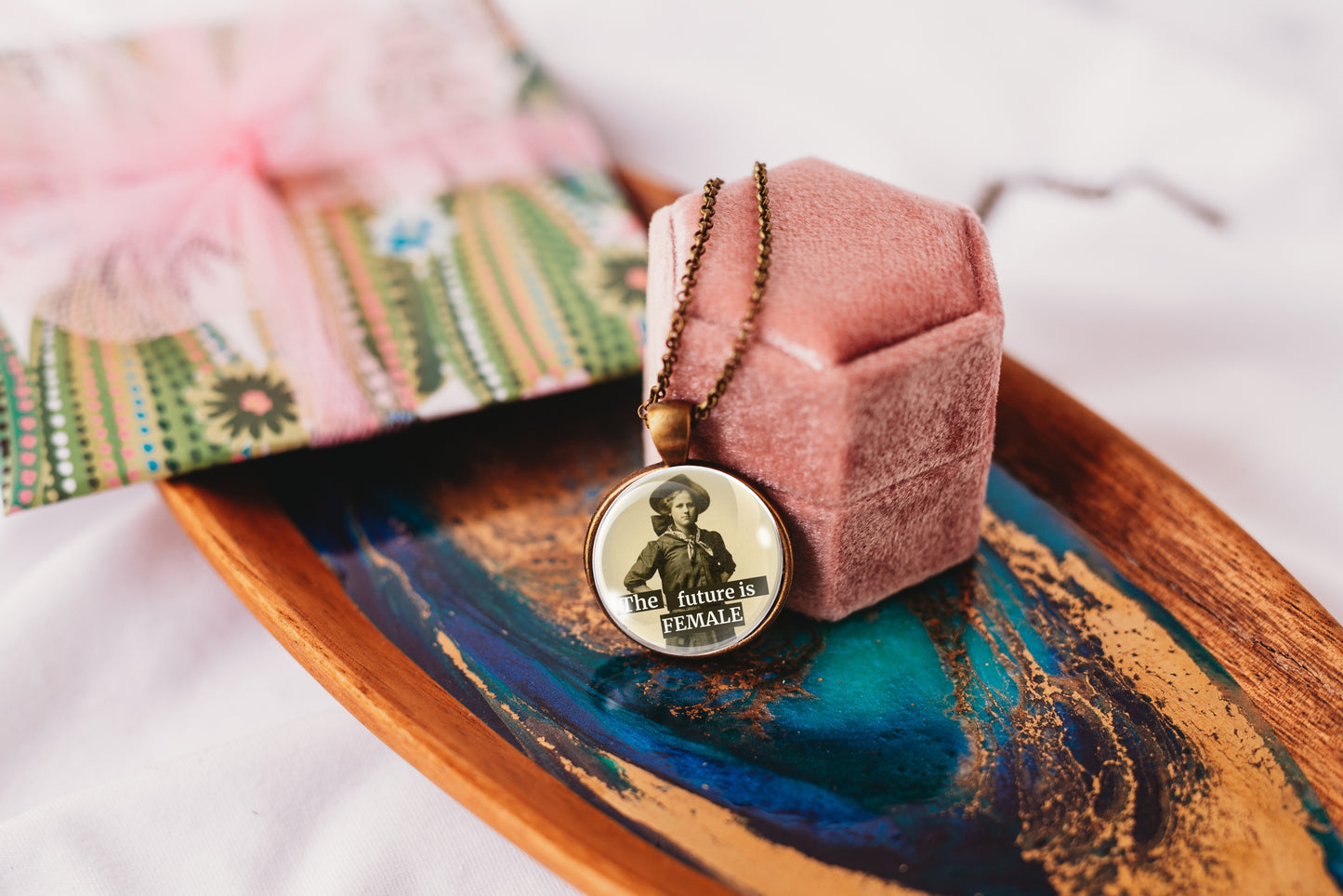 Product photo of a 1-inch glass cabochon pendant necklace featuring “The Future Is Female” with a full-length sepia portrait of a vintage woman on a 20-inch chain.