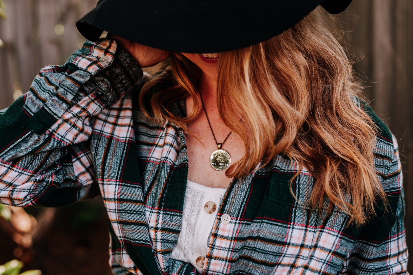 Person wearing a plaid jacket and black hat with a blurred background