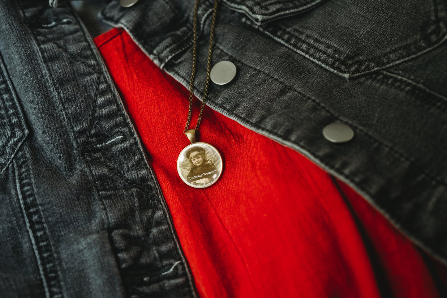 Product photo of a 1-inch glass cabochon pendant necklace featuring “Underage Woman” with a sepia portrait of a young vintage girl on a 20-inch chain.