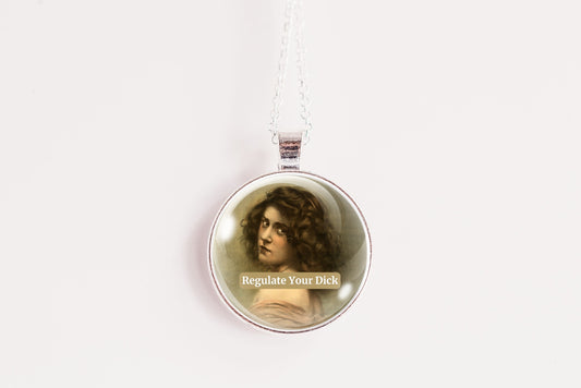 Product photo of a 1-inch glass cabochon pendant necklace featuring “Regulate Your Dick” with a sepia portrait of a curly-haired vintage woman on a 20-inch chain against a plain white background.