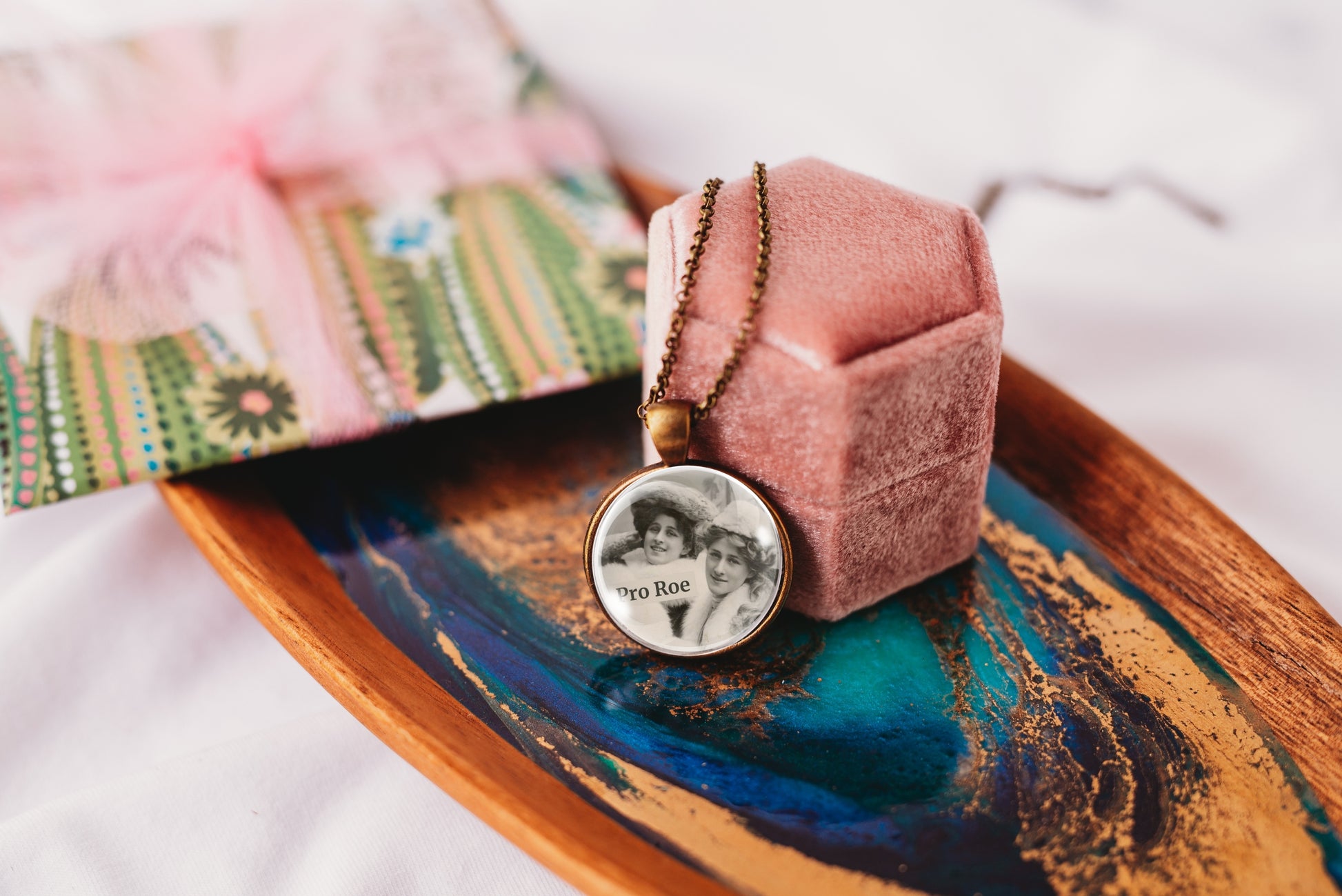 Product photo of a 1-inch glass cabochon pendant necklace featuring “Pro Roe” with two vintage women wearing decorative hats on a 20-inch chain.