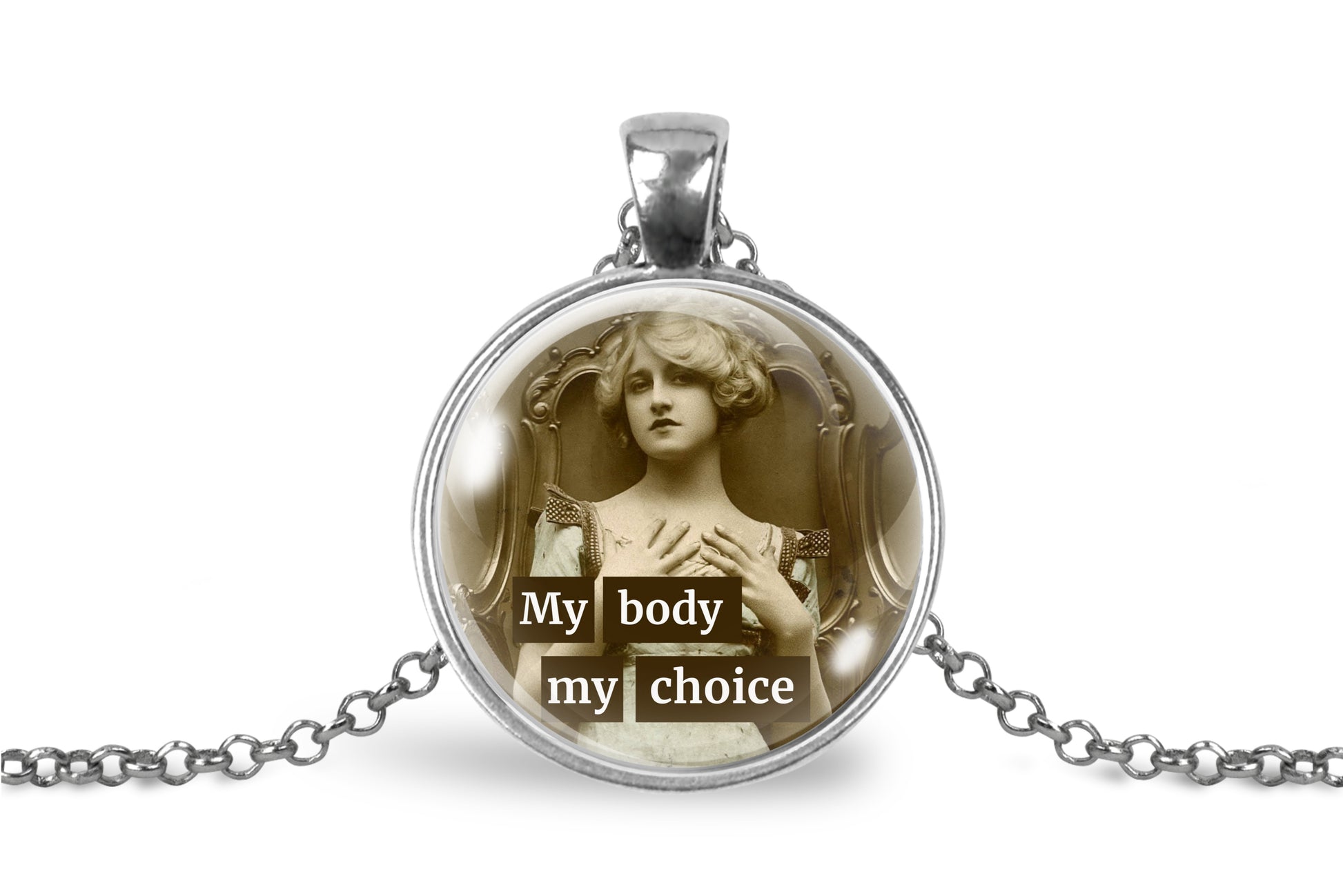 A silver pendant necklace featuring a circular glass dome with a sepia-toned vintage illustration of a woman and the text 'My body my choice' in white lettering, shown on a white background with a silver chain.