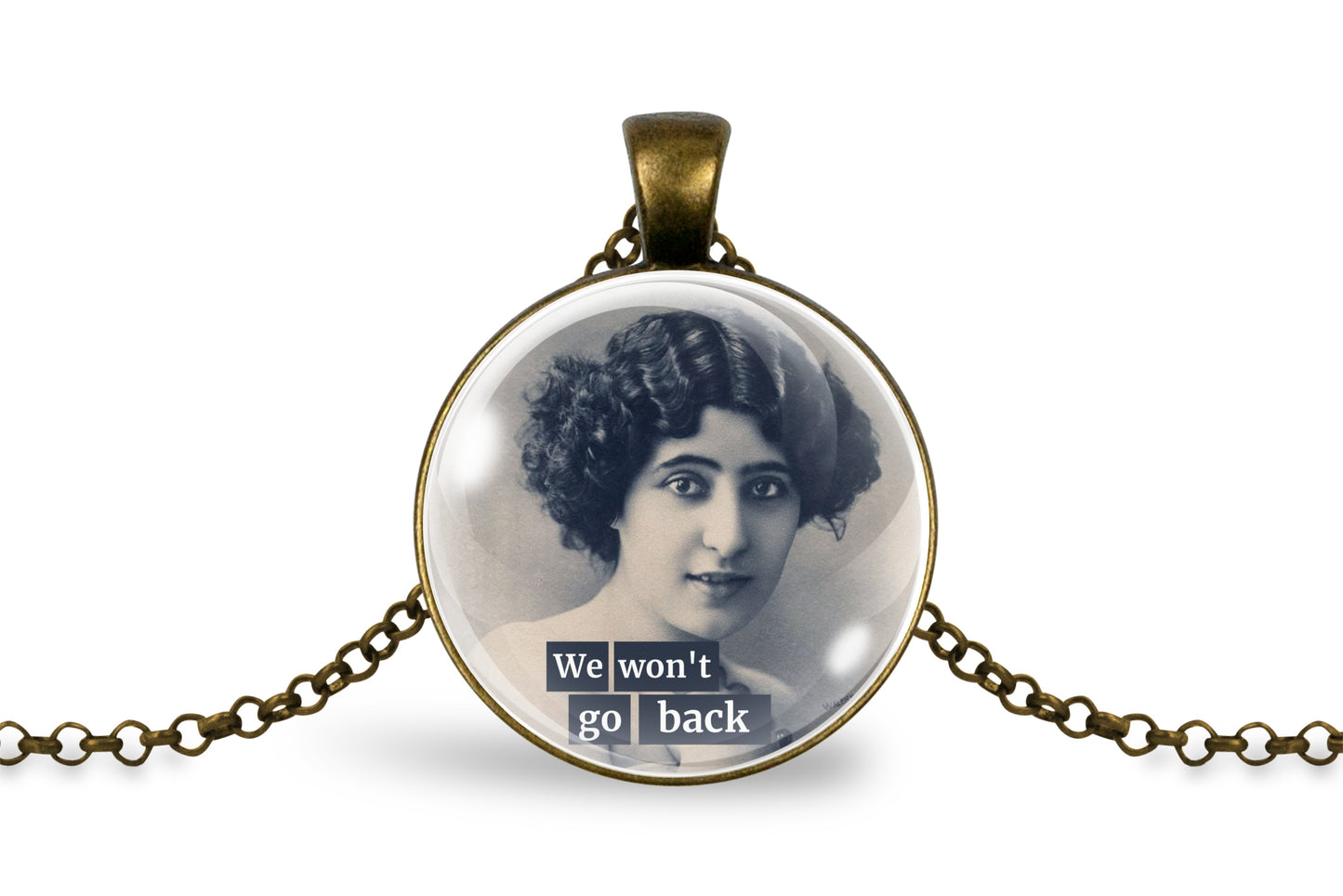 An antique-inspired bronze pendant necklace featuring a vintage black-and-white portrait of a woman with the text 'We won't go back' in white lettering on a dark banner, displayed on a clean white background.