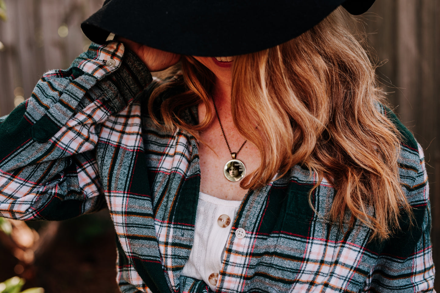 Person wearing a plaid jacket and black hat with a blurred background