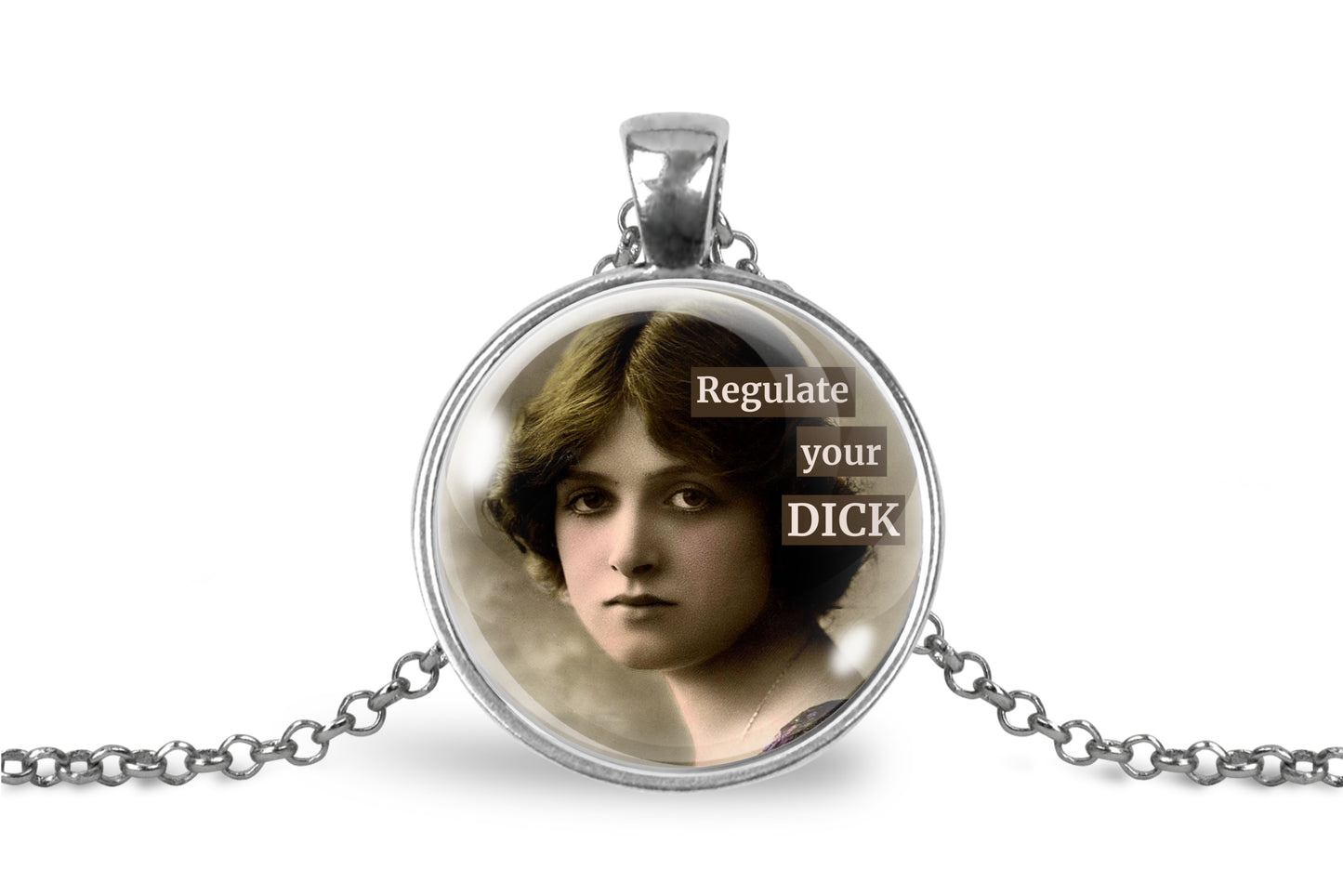 A silver pendant necklace featuring a circular glass cabochon with a vintage-style portrait of a woman and the text 'Regulate your DICK' in white lettering on a brown background, displayed on a clean white background.