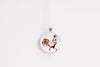 Round pendant with a design of a floral silhouette rooster on a white background