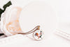 Necklace with a round pendant featuring a rooster design on a white surface.