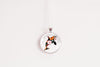 Round pendant with a floral whale design on a white background