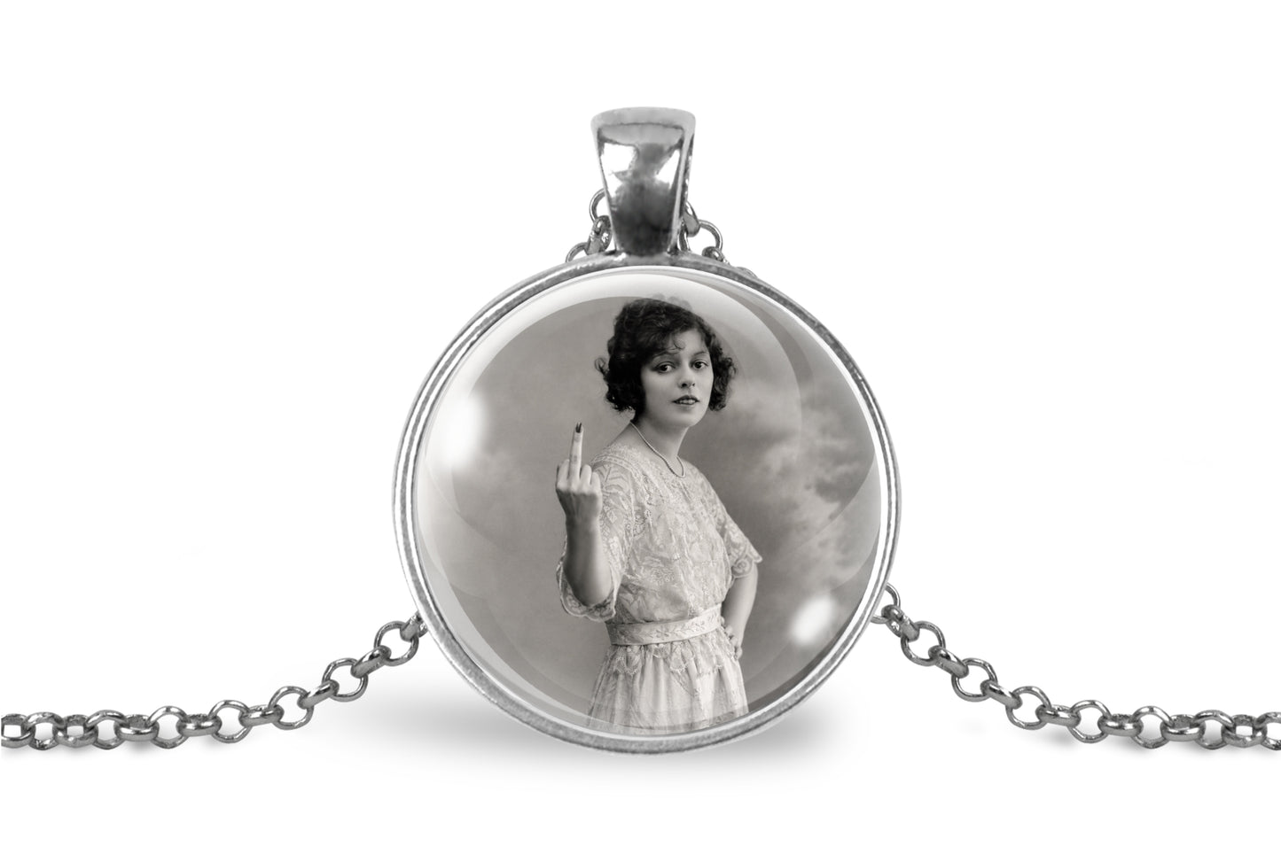 A silver-toned round pendant necklace on a white background, featuring a vintage black-and-white portrait of a woman in a dress holding up her middle finger.